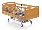 Cama geriátrica con cabecero, piecero y barandas de madera sobre carro elevador con ruedas